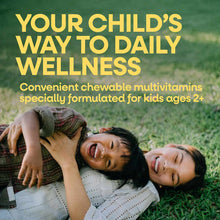 Bottle of Alive Kids chewable multivitamins with yellow text overlay and children playing on grass below.