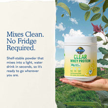 White jar of Garden of Life Clear Whey Protein powder held in a hand against a nature background with sky and foliage.