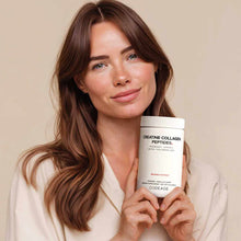 Woman holding white Codeage Creatine Collagen Peptides powder container with white cap against neutral background.