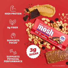 MOSH High Protein Bar in Peanut Butter Cup flavor surrounded by peanuts and chocolate pieces on red background.
