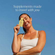 Yellow Cymbiotika supplement bottle held by person against blue background.
