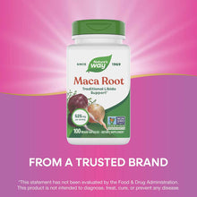 Nature's Way Maca Root supplement bottle with green cap, 525mg per serving, 100 vegan capsules, against pink background.