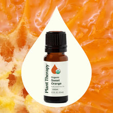 Amber glass bottle with black cap containing Plant Therapy Organic Sweet Orange essential oil, displayed against orange citru