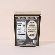 Dark resealable pouch of roasted pistachios with beige and black label displaying nutrition facts and product description.