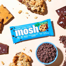 MOSH plant-based protein bar in blue wrapper with Brain Chocolate Chip Cookie flavor, surrounded by chocolate pieces and cook