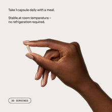 Hand holding a single white capsule, labeled 30 servings.