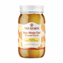 Clear glass jar containing golden-brown sea moss gel with white screw-top lid and True Sea Moss label featuring mango and pin