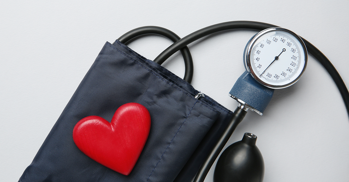 A blood pressure monitor with a red heart shape on the cuff, symbolizing heart health. The image conveys a message of healthcare and wellness.