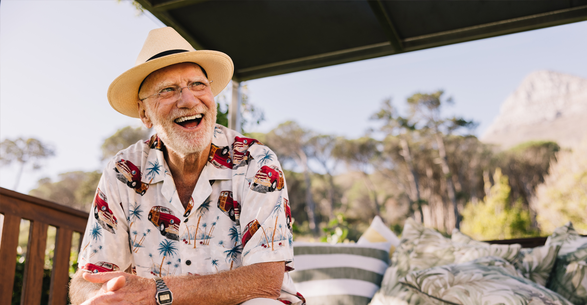 An older man laughing outdoors