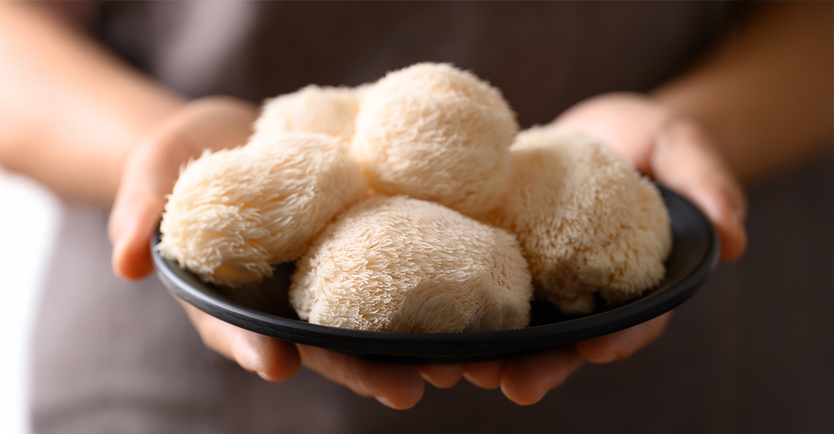 A person holding mushrooms in a wooden bowl