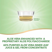 Clear glass bowl containing pale yellow aloe vera juice with wild berry flavoring against a green background.