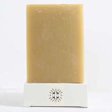 A rectangular tan bar of soap stands upright on a white box printed with a black LSF emblem.