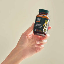 Amber glass bottle of Gaia Herbs Berberine & Milk Thistle supplement held in hand against neutral background.