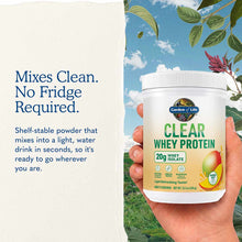 White container of Garden of Life Clear Whey Protein with mango flavor label held in hand against nature background.