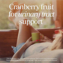 Person holding a yellow mug with text overlay about cranberry fruit for urinary tract support.