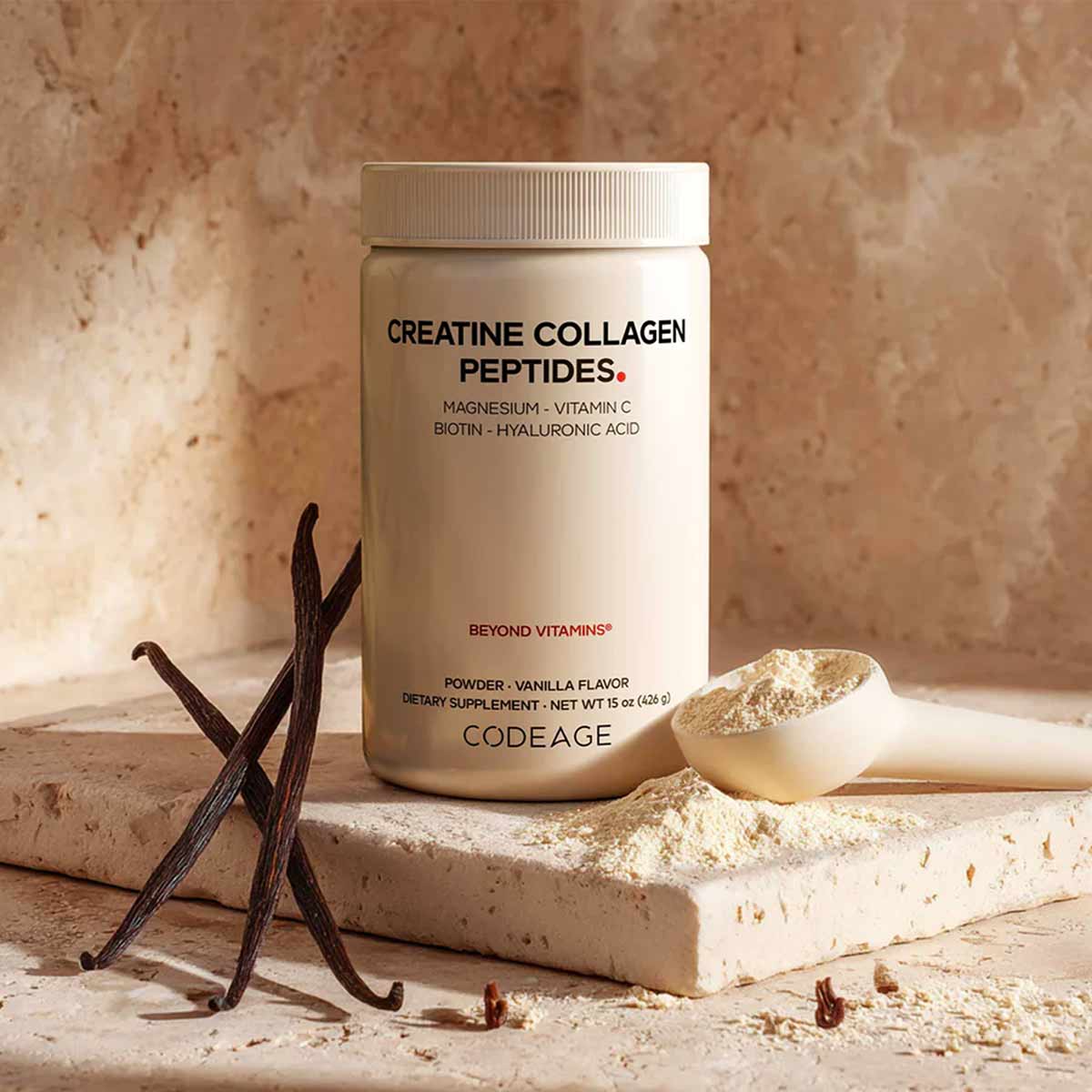 Cream-colored powder container labeled Creatine Collagen Peptides by Codeage with vanilla beans and scoop on stone surface.