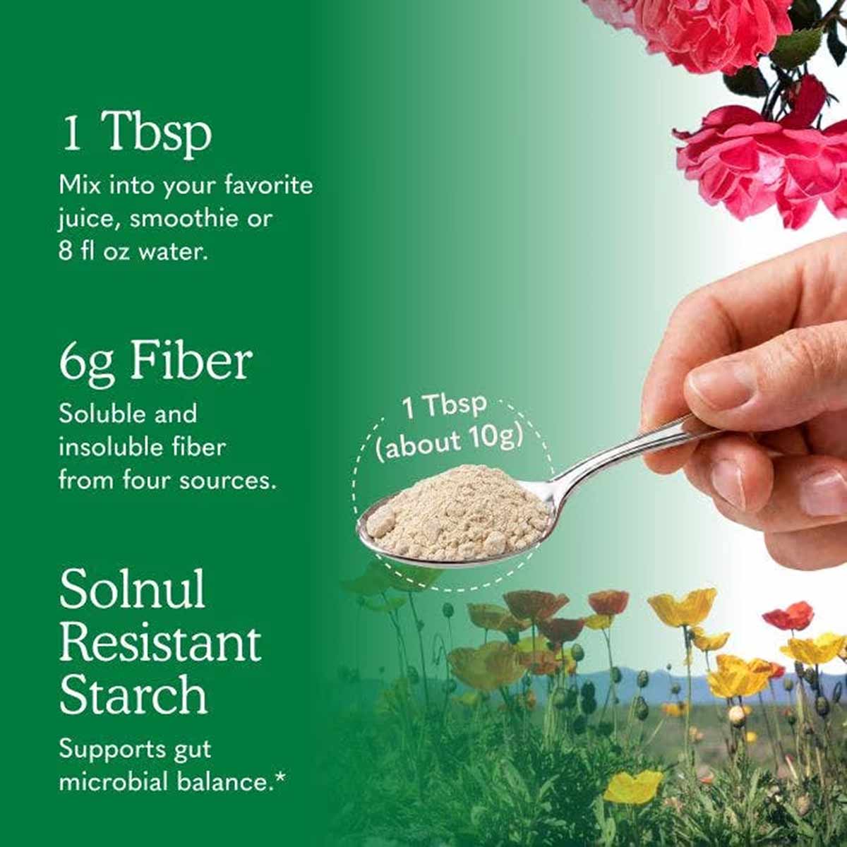 A hand holds a metal spoon with one tablespoon of beige fiber powder against a green background with flowers and serving text.