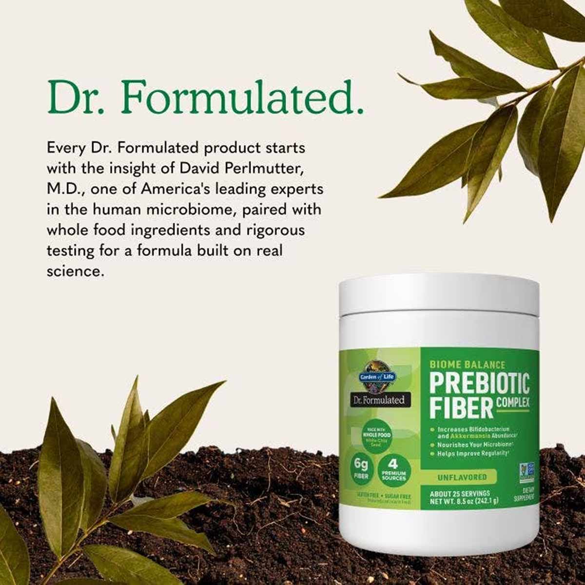 A white tub of unflavored Biome Balance Prebiotic Fiber Complex with a green label rests on dark soil beside leafy branches.
