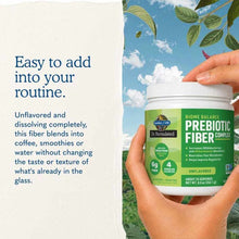Two hands hold a green and white tub of unflavored prebiotic fiber complex against a blue sky, beside text about easy use.