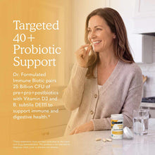 Bottle of Dr. Formulated Immune Biotic supplement displayed on table next to glass of water and capsules.