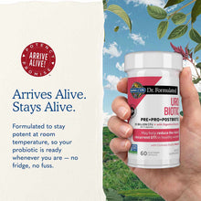 White bottle of Dr. Formulated URO Biotic probiotic supplement with red and black label held in hand against outdoor backgrou