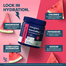 Dark blue canister of ElectroMag electrolyte powder by True Grace surrounded by watermelon slices on pink background.