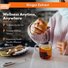 Person in pink sweater holding ginger extract bottle above cup of brown liquid, with fresh ginger root and sliced ginger on p