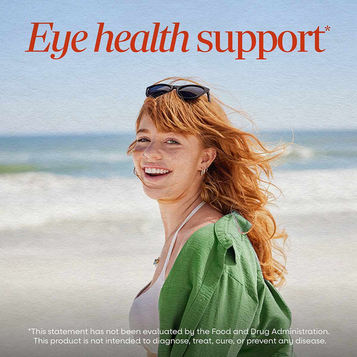 Woman with red hair wearing sunglasses on beach with "Eye health support" text overlay.
