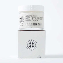A glass jar of Little Seed Farm goat's milk moisturizer with a white lid rests on top of its white box.