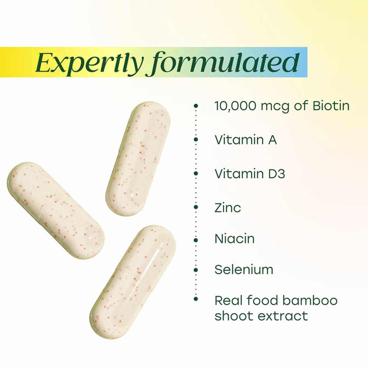 Three cream-colored capsules with red speckles next to ingredient list including biotin, vitamins, minerals, and bamboo extra