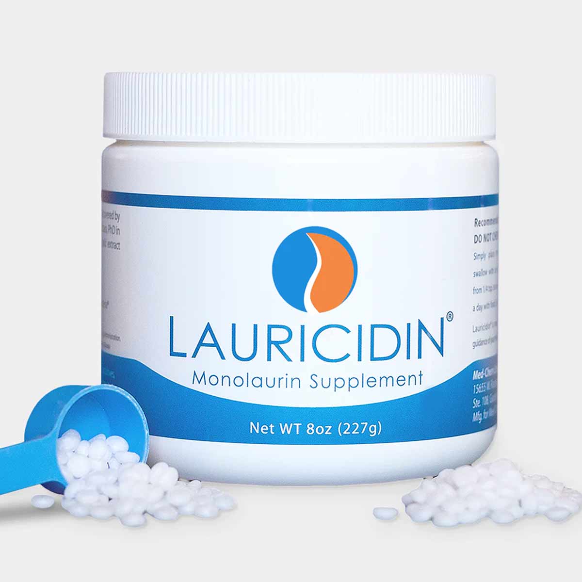 White container with blue band labeled Lauricidin Monolaurin Supplement 8oz, with blue measuring scoop and white pellets.