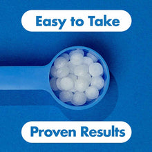 White spherical supplement pellets in a blue measuring spoon against a blue background.