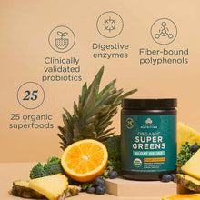 Dark glass jar of Ancient Nutrition Organic SuperGreens + Bloat Relief surrounded by pineapple, orange, blueberries, broccoli