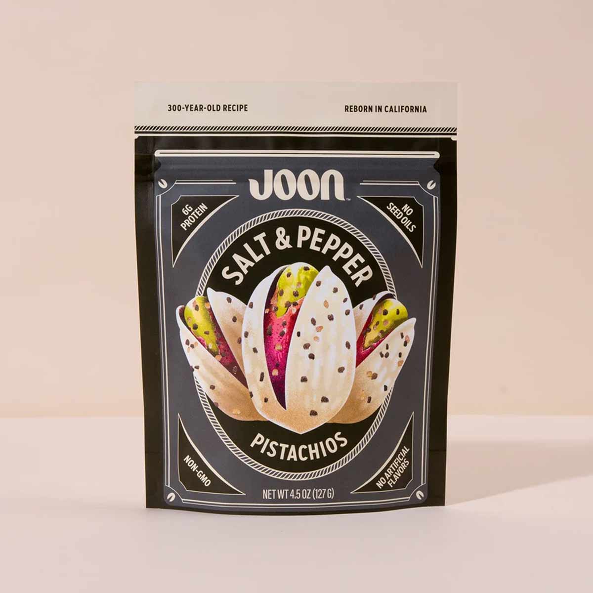 Joon brand salt and pepper pistachios in a black pouch with illustrated pistachio design and product details.