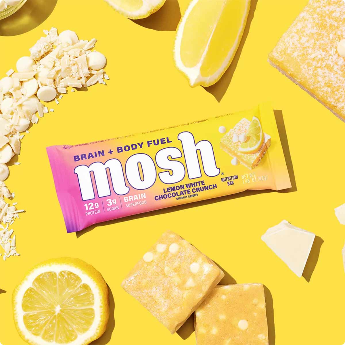 MOSH Lemon White Chocolate Crunch protein bar with 12g protein, surrounded by lemon slices and oats on yellow background.