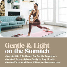 Woman performing a leg stretch on a pink yoga mat in a bright living room with a turquoise sofa.