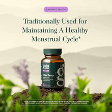Gaia Herbs Vitex Berry supplement bottle with green cap on soil with purple flowers and green plants in background.